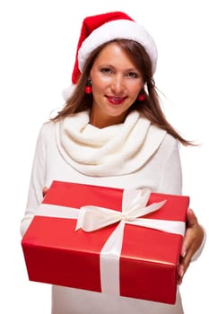Pretty brunette woman with Christmas hat and big red gift cheerfullaughing isolated against white background