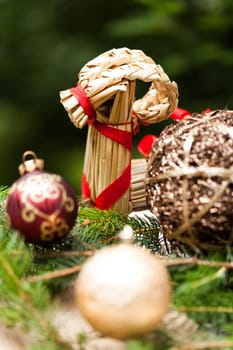 golden Christmas tree balls glittering on tannin branches with snow as macro detail
