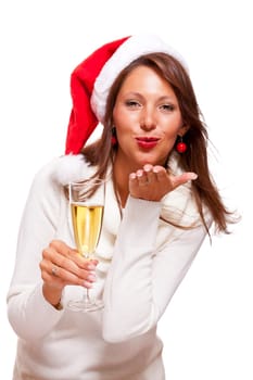 Attractive woman with red Santa hat holds a glass of champagne in her hand and smiles isolated on white background freeing text space