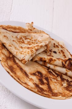 delicious fresh crepes pancakes pancakes on a white plate on a rustic white wooden board