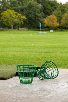 Driving range with golf balls and tee at a golf course in summer outdoors