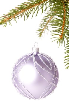 Traditional Christmas ball hung on a green fir branch isolated against a white background