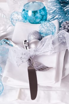 Stylish table with Christmas decoration in turquoise and silver shiny with cutlery