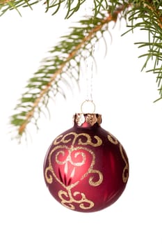 Traditional Christmas ball hung on a green fir branch isolated against a white background