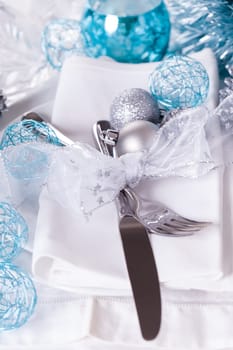 Stylish table with Christmas decoration in turquoise and silver shiny with cutlery