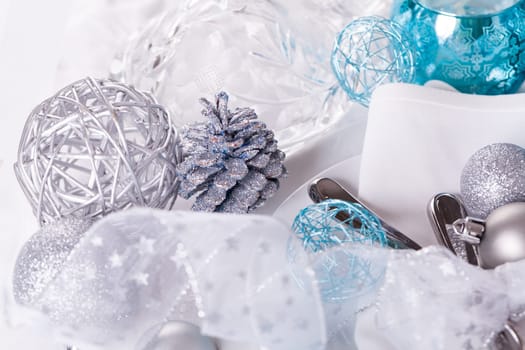 Stylish table with Christmas decoration in turquoise and silver shiny with cutlery