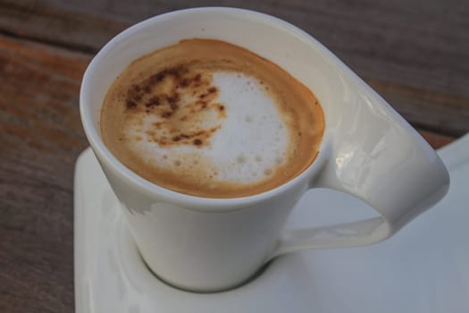 Cup of cappuccino coffee on wooden table