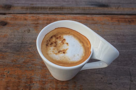 Cup of cappuccino coffee on wooden table