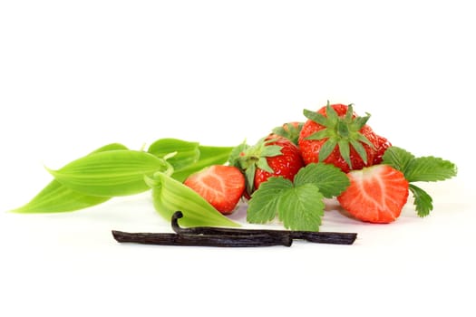 a vanilla pod with vanilla leaves and fresh strawberries