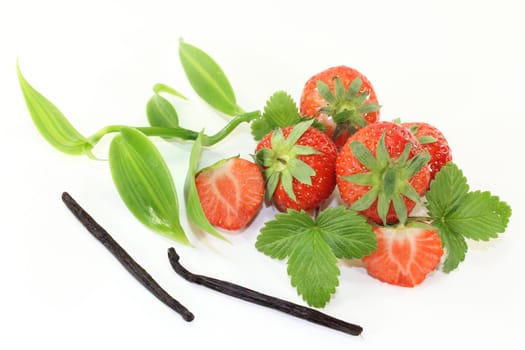 a vanilla pod with vanilla leaves and fresh strawberries