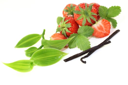 a vanilla pod with vanilla leaves and fresh strawberries
