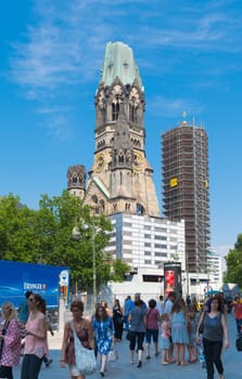 Kaiser Wilhelm Memorial Church next to a modern bell tower in Berlin, Germany. Historical church hit and damaged by allied air forces during the Second World War and never restored.