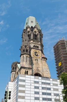 Kaiser Wilhelm Memorial Church next to a modern bell tower in Berlin, Germany. Historical church hit and damaged by allied air forces during the Second World War and never restored.