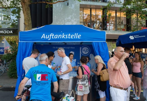 people getting free cold water on a hot day in Berlin. It is promotion of the Berlin water companies