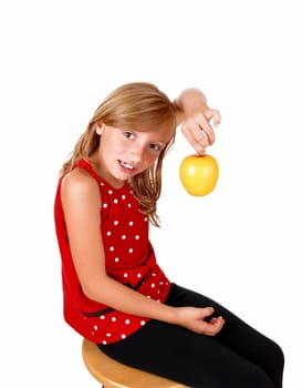 A young blond girl is playing with her yellow apple she likes to eat,.isolated on white background..