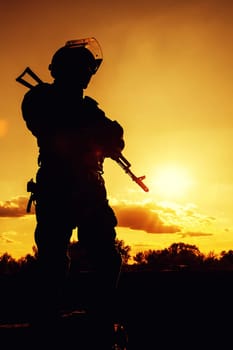 Silhouette of police officer with weapons at sunset