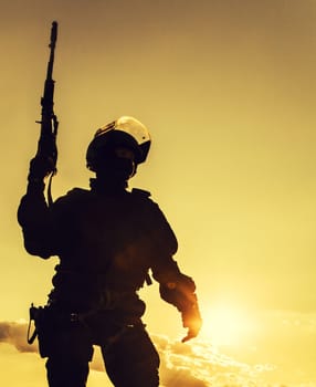 Silhouette of police officer with weapons at sunset
