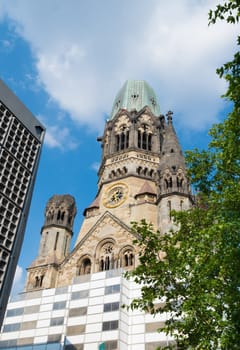 Kaiser Wilhelm Memorial Church next to a modern bell tower in Berlin, Germany. Historical church hit and damaged by allied air forces during the Second World War and never restored.