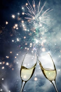 Glasses with champagne against holiday lights and clock close to midnight