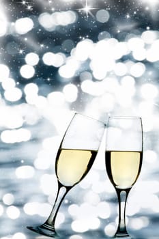 Glasses with champagne against holiday lights and clock close to midnight