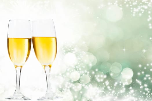 Glasses with champagne against holiday lights and clock close to midnight