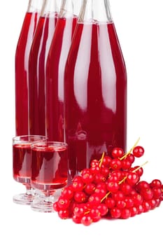 Ripe red currants and syrup or liqueur in a glass and swing top bottles isolated on white background