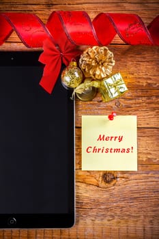 tablet pc with christmas decorations on wooden background