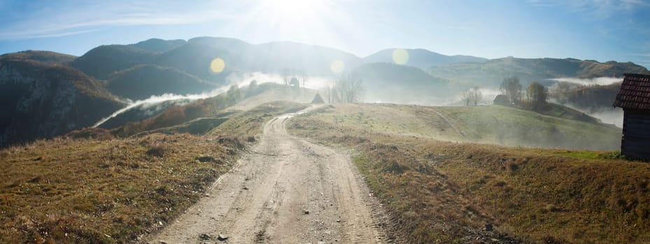 curving road in the mountains in the autumn sunrise