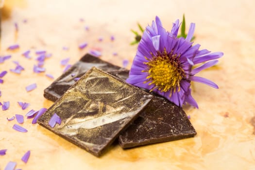 dark chocolate on a wooden table. Decorated with gold leaf. selective Focus