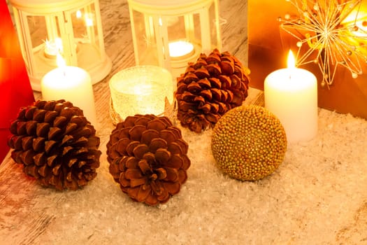 Christmas setting with candles, pine cones, shopping bags and baubles..