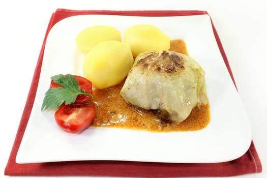 a plate of cabbage roulade and potatoes