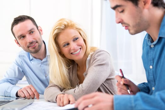 View of a young serious couple meeting a real estate agent