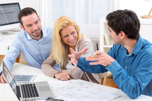 View of a young serious couple meeting a real estate agent