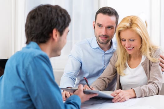 View of a Young attractive couple signing contract