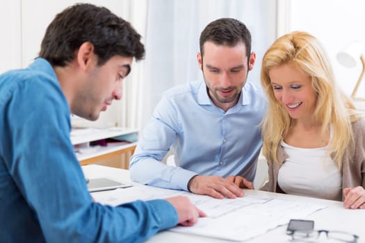 View of a young serious couple meeting a real estate agent