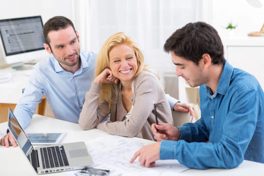 View of a young serious couple meeting a real estate agent