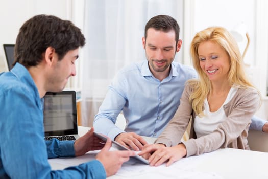 View of a Young attractive couple signing contract on tablet