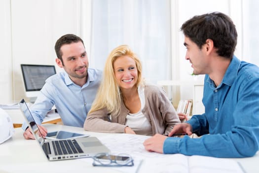 View of a young serious couple meeting a real estate agent