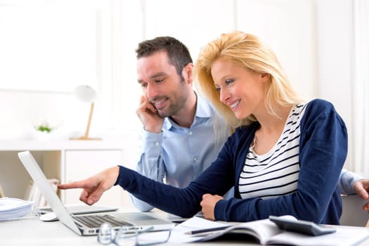 View of a Young attractive couple using laptop at home