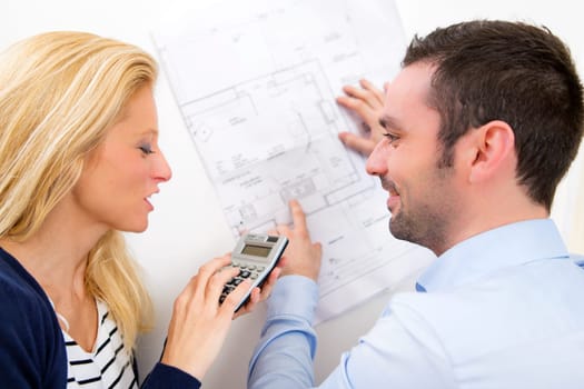 View of a Young couple studying plans of their future house