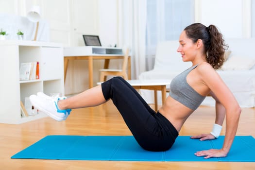 View of a Young attractive girl doing exercise at home