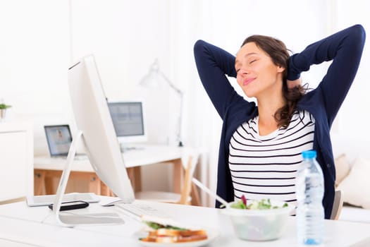 View of a Young attractive woman stretching during a meal break