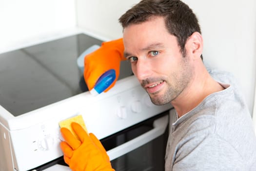 View of a Young attractive man cleaning his flat