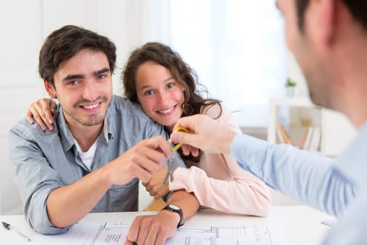 View of a Real estate handing over keys to couple