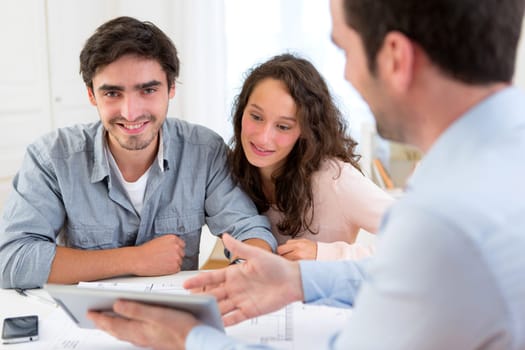 View of a young relaxed couple meeting a real estate agent