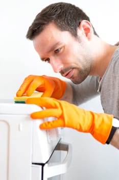 View of a Young attractive man cleaning his flat