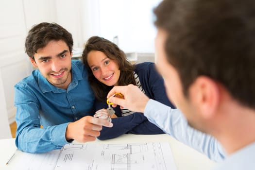 View of a Real estate handing over keys to couple