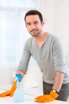 View of a Young attractive man cleaning his flat
