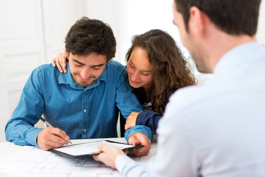 View of a Young attractive couple signing contract
