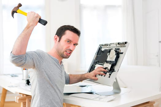 View of a Young attractive man angry against computer